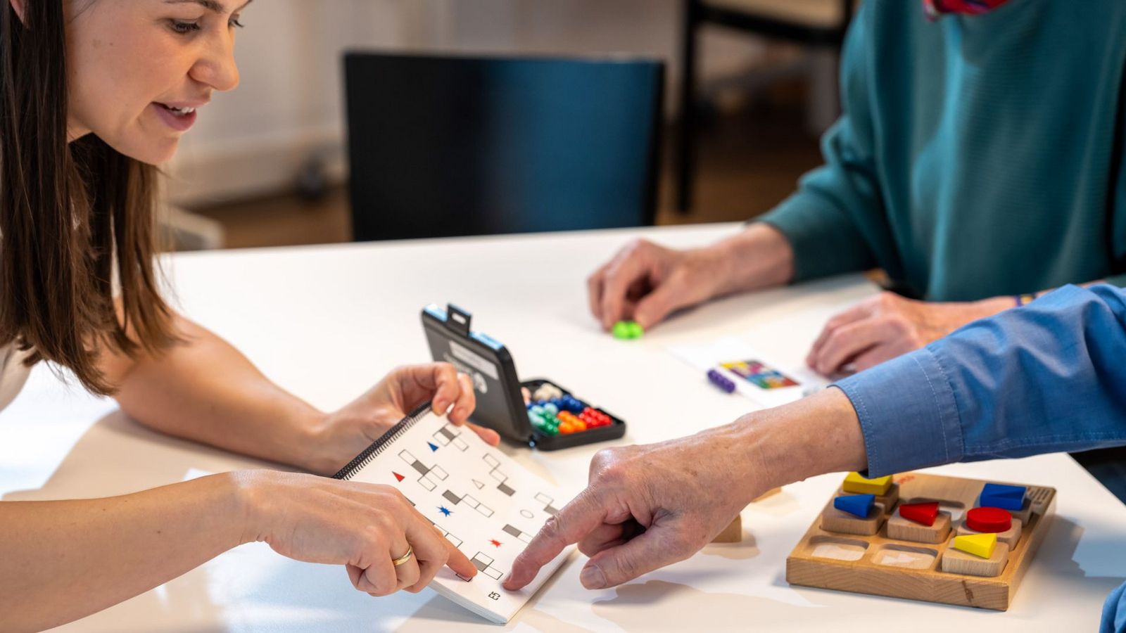 Eine Patientin zeigt auf ein farbiges Feld bei einem Gedächtnisspiel