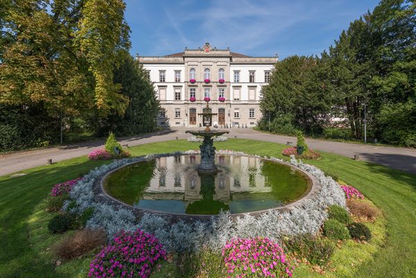 Das denkmalgeschützte Hauptgebäude der PDAG mit dem römischen Brunnen im Vordergrund