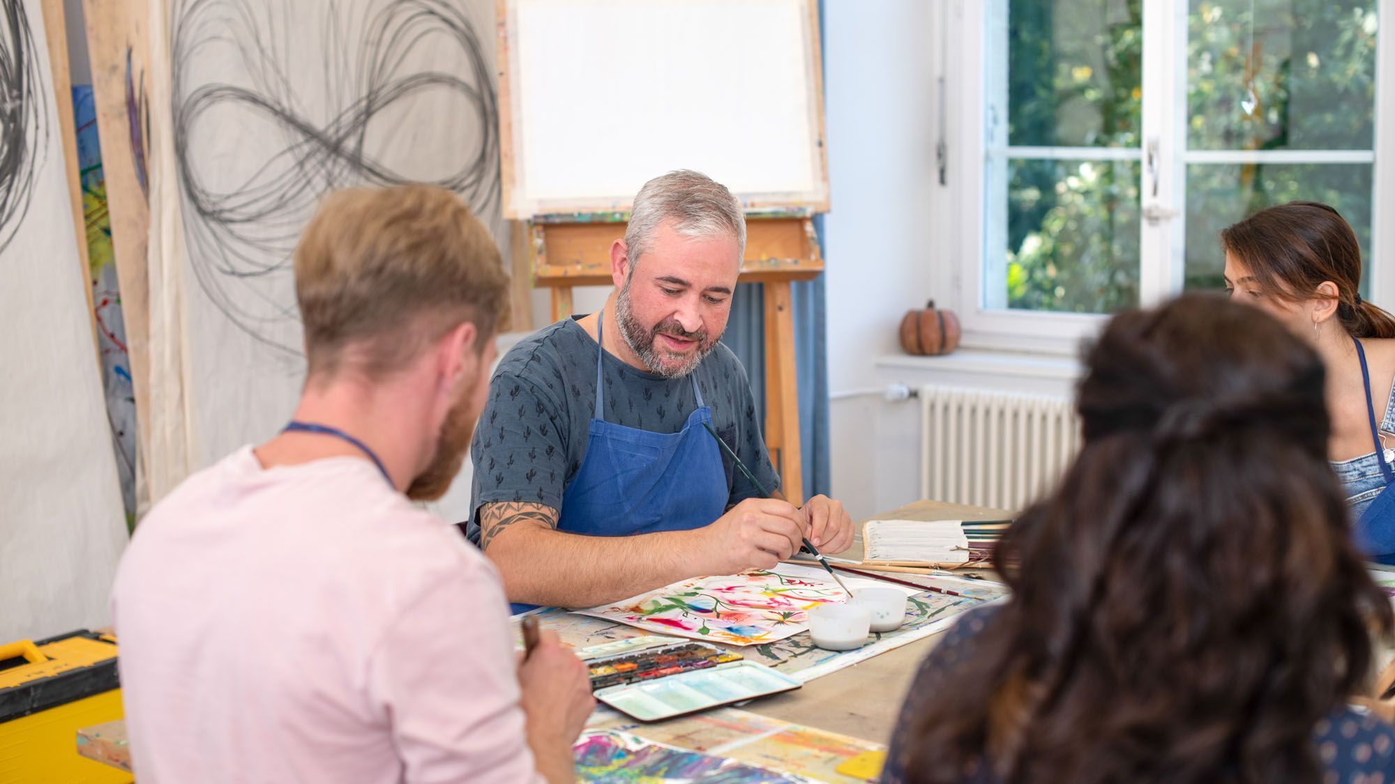 Ein Kunsttherapeut zeigt, wie man mit Farbe und Pinsel arbeitet