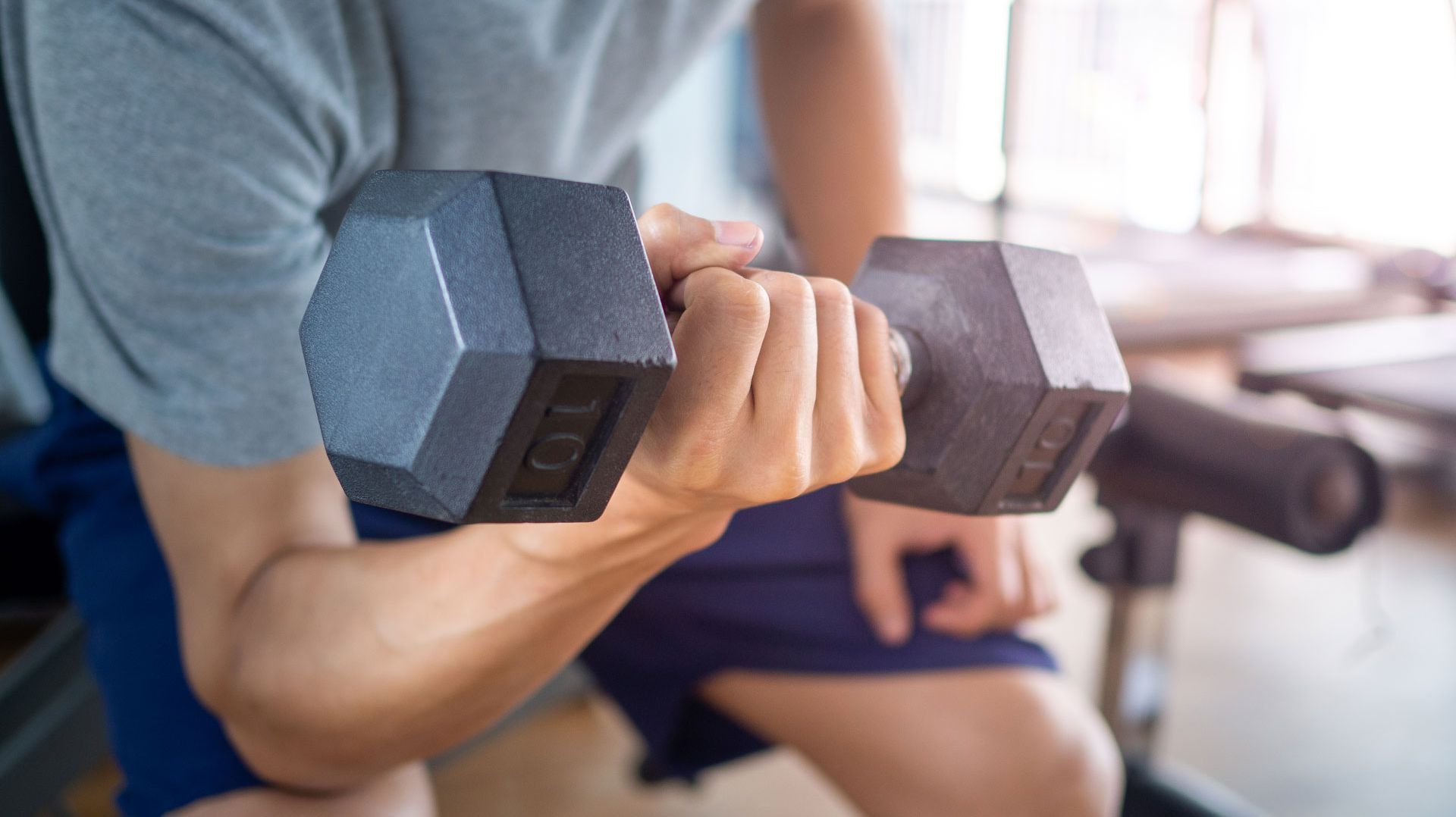 Mann beim Krafttraining mit einer Hantel