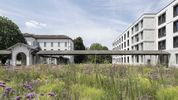 Ein überdachter Durchgang verbindet das historische Klinikgebäude mit dem modernen Neubau