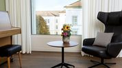 Ein Zimmer mit einem gemütlichem Sessel und einem Klavier