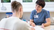 Eine Ergotherapeutin geht mit einem Patienten eine Checkliste durch