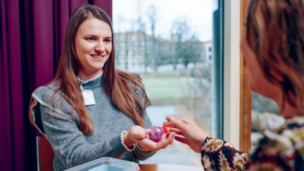 Fachperson und Patientin bei einer Übung mit Hilfsgegenständen